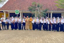 Siswa SMPN 1 Nusawungu berfoto bersama pelatih setelah memborong 16 piala dan medali dalam ajang Kejurda Tapak Suci Cilacap di depan gedung sekolah.
