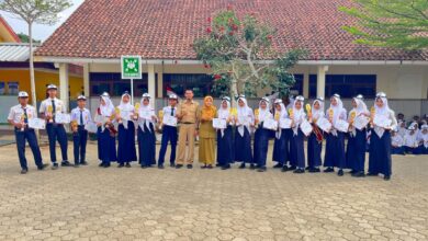 Siswa SMPN 1 Nusawungu berfoto bersama pelatih setelah memborong 16 piala dan medali dalam ajang Kejurda Tapak Suci Cilacap di depan gedung sekolah.