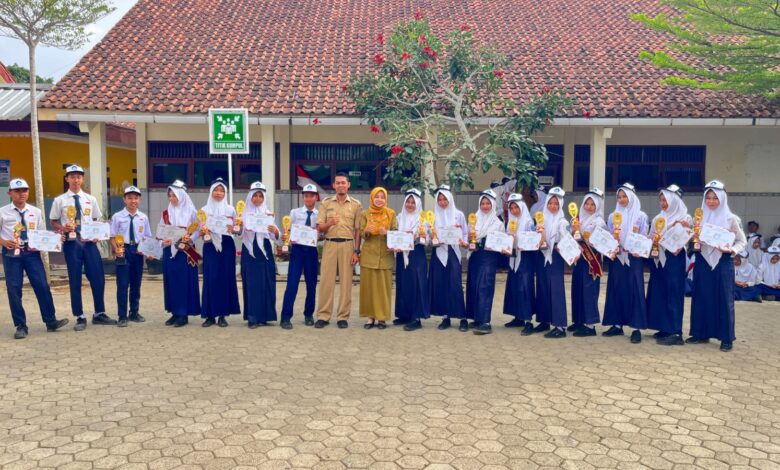 Siswa SMPN 1 Nusawungu berfoto bersama pelatih setelah memborong 16 piala dan medali dalam ajang Kejurda Tapak Suci Cilacap di depan gedung sekolah.