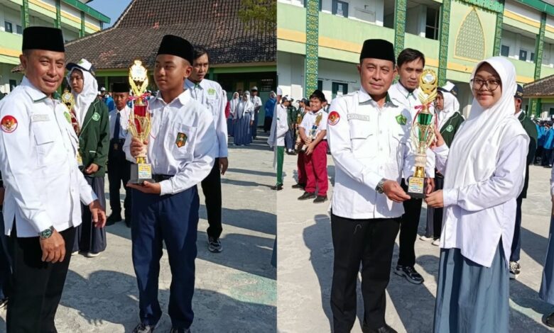 Siswa At-Tajdid Blora juara OMI 2026 menerima piala penghargaan dari Kepala Kemenag Blora Roziqun saat upacara di MTsN Blora