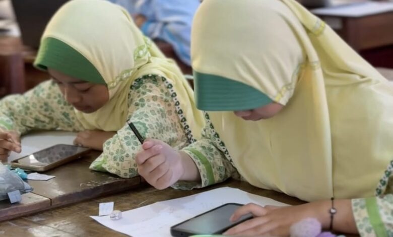 Dua siswa SD Muhammadiyah Temanggung sedang serius mengerjakan soal dalam babak semifinal OSM Jateng Season 5 Temanggung.