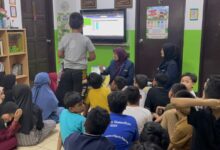 Dosen FKI UMS mendampingi anak-anak Sanggar Bimbingan Kepong Malaysia belajar computational thinking menggunakan media interaktif di layar TV.