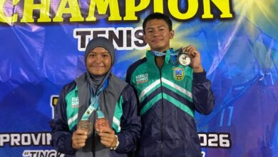 Dua atlet pelajar tenis SMA Muhammadiyah Kudus, Anandisti Laroya Askana (hijab) dan Ahrenza Cyrill Mahira, memegang tiga medali mereka di panggung POPDA Jawa Tengah 2026.