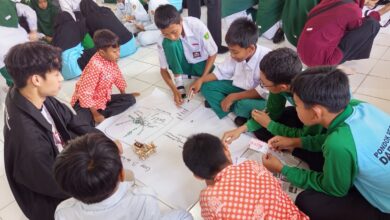 Santri Pondok Pesantren Darul Arqom Purworejo dan mahasiswa UTP Malaysia berdiskusi mengerjakan modul modul STEM di atas kertas karton.