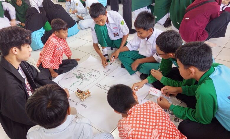 Santri Pondok Pesantren Darul Arqom Purworejo dan mahasiswa UTP Malaysia berdiskusi mengerjakan modul modul STEM di atas kertas karton.