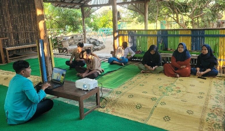 Mahasiswa PKM-PM UMS memberikan pemaparan materi literasi digital anak dan pelatihan Canva menggunakan laptop dan proyektor di saung Rumah Anak Yatim Arrahmah Boyolali.