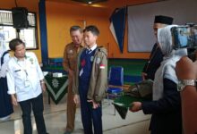 Pemasangan jaket kontingen kepada siswa SMP Mutual Kota Magelang saat pelepasan International Student Festival oleh jajaran pejabat.