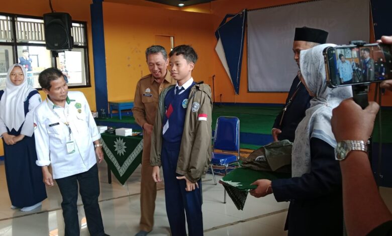 Pemasangan jaket kontingen kepada siswa SMP Mutual Kota Magelang saat pelepasan International Student Festival oleh jajaran pejabat.