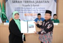 Titik Kodariah menerima naskah dokumen dalam acara sertijab Kepala SMK Muhammadiyah 2 Jatinom Klaten.