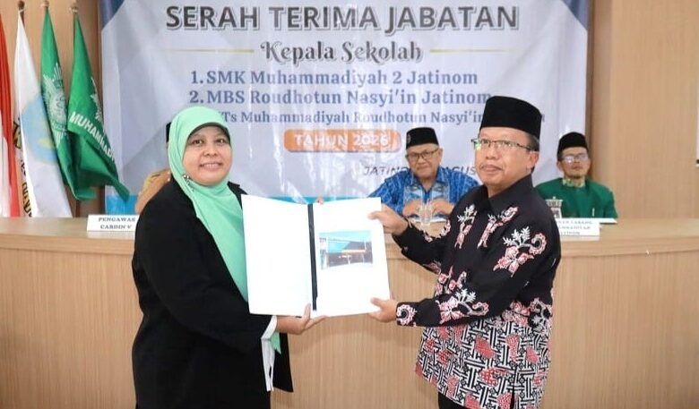 Titik Kodariah menerima naskah dokumen dalam acara sertijab Kepala SMK Muhammadiyah 2 Jatinom Klaten.