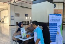 Petugas medis RS UMS AR Fachrudin memeriksa suhu tubuh calon peserta dalam agenda tes kesehatan jamaah haji UMS di Kampus 2 UMS.