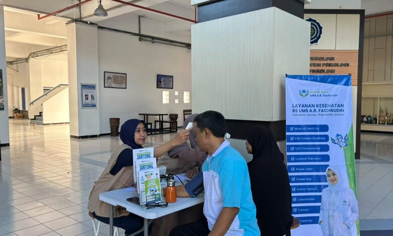 Petugas medis RS UMS AR Fachrudin memeriksa suhu tubuh calon peserta dalam agenda tes kesehatan jamaah haji UMS di Kampus 2 UMS.