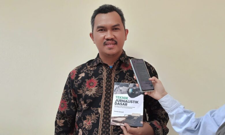 Dosen UHAMKA Hendra Apriyadi menunjukkan modul Teknik Jurnalistik Dasar saat sesi wawancara peluncuran buku