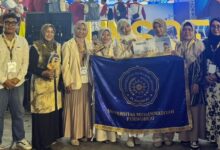 Tim Dehiera UMPWR sabet Juara 1 KMI Expo XVII 2026 pamerkan piala dan bendera kampus UMPWR bersama dosen pendamping