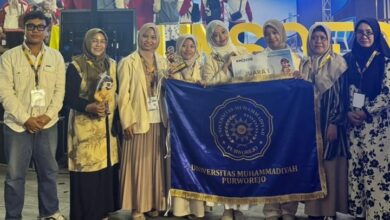 Tim Dehiera UMPWR sabet Juara 1 KMI Expo XVII 2026 pamerkan piala dan bendera kampus UMPWR bersama dosen pendamping