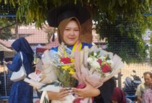 Ajeng Bai'ah Nunif wisudawati peraih Beasiswa PSDK UMP memegang buket bunga usai kelulusan