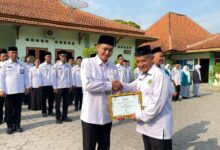 Kepala Kemenag Sragen H Fatchur Rochman menyerahkan piagam penghargaan Nilai TKA Terbaik se-Jawa Tengah kepada Kepala MA DIMSA Sragen Fuad Ibrahim