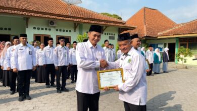 Kepala Kemenag Sragen H Fatchur Rochman menyerahkan piagam penghargaan Nilai TKA Terbaik se-Jawa Tengah kepada Kepala MA DIMSA Sragen Fuad Ibrahim