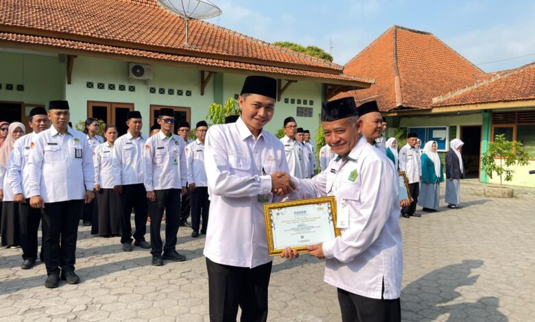 Kepala Kemenag Sragen H Fatchur Rochman menyerahkan piagam penghargaan Nilai TKA Terbaik se-Jawa Tengah kepada Kepala MA DIMSA Sragen Fuad Ibrahim