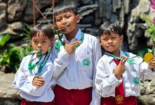 Tiga siswa MI Muhammadiyah Purwodadi mengenakan seragam sekolah sambil memamerkan medali kejuaraan pencak silat Temanggung Open Championship.