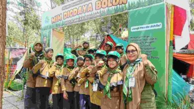 Siswa Pandu Athfal MIM Digdaya Bolon berpose bersama pembina di depan gapura tenda dalam ajang MISC HW Karanganyar.