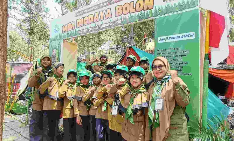 Siswa Pandu Athfal MIM Digdaya Bolon berpose bersama pembina di depan gapura tenda dalam ajang MISC HW Karanganyar.