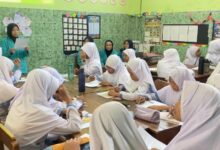 Tim pengabdi UMS mendampingi siswa MI Muhammadiyah Gedongan dalam sesi pengerjaan lembar kerja edukasi pemilahan sampah di ruang kelas.