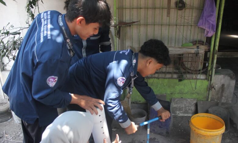 Mahasiswa Kesehatan Masyarakat UMS mempraktikkan cara membuat lubang resapan biopori menggunakan alat bor tanah manual di Desa Purwogondo.