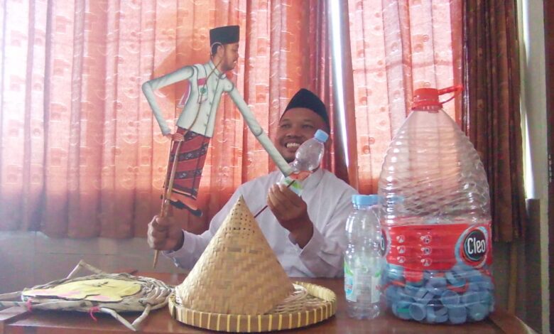 Ustaz Dwi Jatmiko memegang Wayang Sak Semen Press dan botol plastik untuk sosialisasi pengelolaan sampah di SD Muhammadiyah 1 Solo.