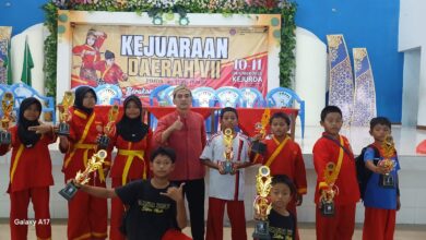 Santri Madin Al Ishlah Dorang berfoto bersama pelatih sambil memegang piala kejuaraan pada Kejurda Tapak Suci Jepara 2026.
