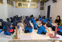 Murid-murid SD Muhammadiyah PK Solo duduk bersila di ruangan Batik Puspita Mekar saat belajar membatik dan mewarnai kain.