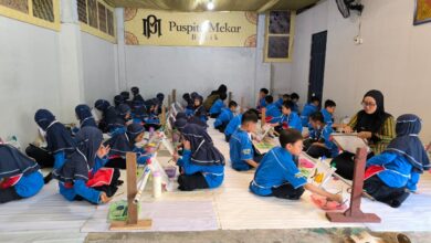 Murid-murid SD Muhammadiyah PK Solo duduk bersila di ruangan Batik Puspita Mekar saat belajar membatik dan mewarnai kain.