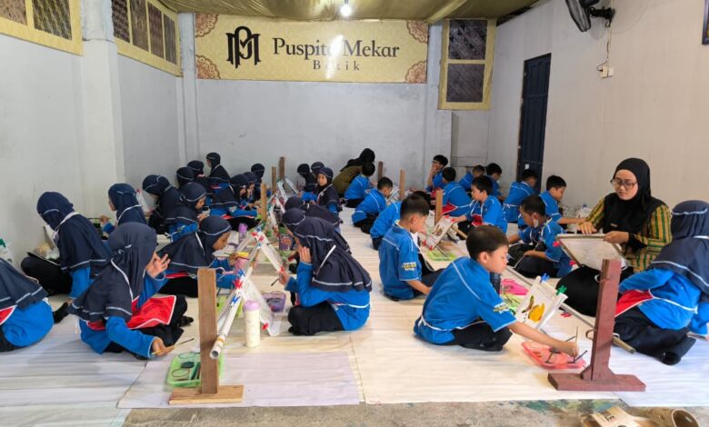 Murid-murid SD Muhammadiyah PK Solo duduk bersila di ruangan Batik Puspita Mekar saat belajar membatik dan mewarnai kain.