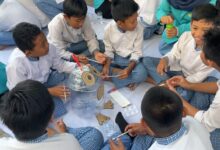 Siswa MI Muhammadiyah Gedongan duduk melingkar sambil mengecat dan menghias galon bekas menjadi tempat sampah edukasi pemilahan sampah UMS.