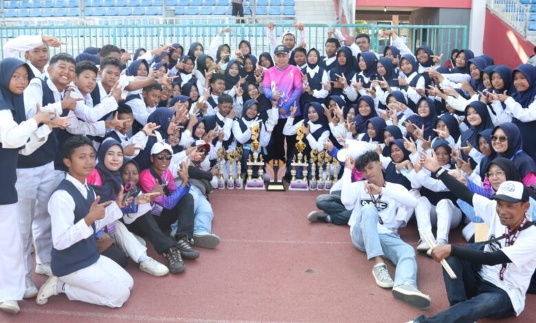 Tim drumband Gita Surya Putra SMP Mutu Plus Cilacap foto bersama memamerkan deretan trofi juara umum Cilacap Drumband Competition 2026 di Stadion Wijayakusuma.