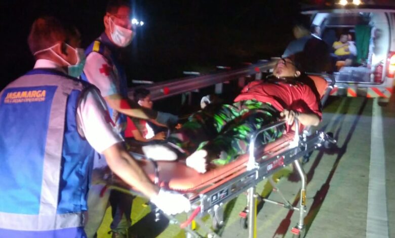 Petugas medis dan Jasa Marga mengevakuasi korban kecelakaan Tol Batang-Weleri dari anggota KOKAM Semarang menggunakan tandu ke dalam ambulans pada malam hari.
