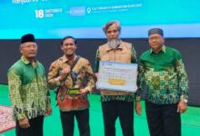 Jajaran pengurus PCM Kebakkramat Karanganyar memegang piala dan piagam Penghargaan Terbaik 2 MOEA UMS 2026 di Edutorium UMS.