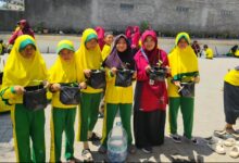 Siswa SDMPK Jogonalan memegang polybag tanaman cabai dalam pelatihan pertanian Milad Muhammadiyah ke-114