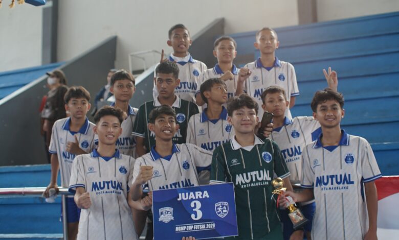 Tim futsal SMP Mutual Magelang berfoto bersama sambil memegang piala dan papan Juara 3 MGMP Cup Futsal 2026 di tribun GOR Samapta.