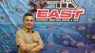 Dosen FIKes UMP Endiyono bersedekap dada di depan latar spanduk pelatihan Emergency Ambulance Service and Team (EAST) RSUD Dr Soetomo Surabaya.