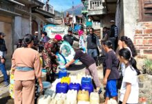 Personel KOKAM dan relawan BikersMu menyalurkan bantuan air bersih ke dalam jeriken warga di Dusun Tanggulanom Temanggung.
