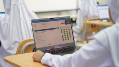 Siswa sekolah mengenakan seragam putih mengikuti Try Out TKA SMP UMP secara berbasis komputer menggunakan laptop.