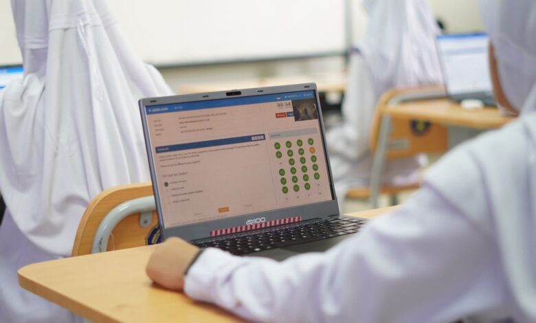 Siswa sekolah mengenakan seragam putih mengikuti Try Out TKA SMP UMP secara berbasis komputer menggunakan laptop.