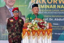 Iskandar Muda Hasibuan menyampaikan pidato di mimbar acara Muhammadiyah didampingi personel Kokam