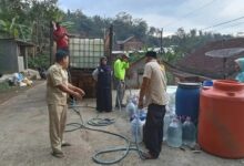 Petugas dan relawan menyalurkan bantuan air bersih dari tangki truk ke galon dan drum milik warga di Temanggung.