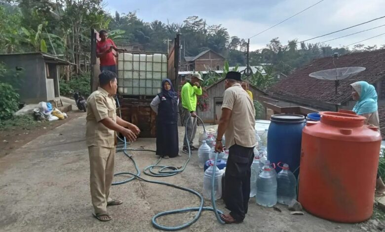Petugas dan relawan menyalurkan bantuan air bersih dari tangki truk ke galon dan drum milik warga di Temanggung.