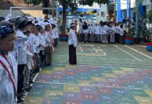 Siswa-siswi MI Muhammadiyah Al Tanbih Kudus berbaris rapi mengenakan busana muslim dan ikatan kepala saat mengikuti apel peringatan Hari Santri 2026 di halaman sekolah.