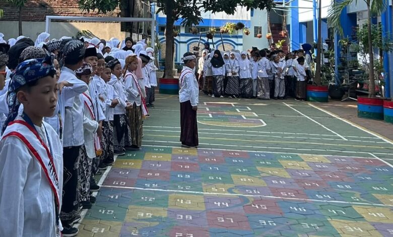 Siswa-siswi MI Muhammadiyah Al Tanbih Kudus berbaris rapi mengenakan busana muslim dan ikatan kepala saat mengikuti apel peringatan Hari Santri 2026 di halaman sekolah.