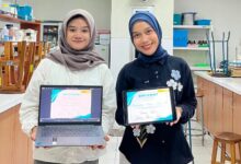 Dua mahasiswa Farmasi UMP menunjukkan sertifikat juara 1 kompetisi poster ilmiah ANESCO 2.0 di layar laptop dan tablet