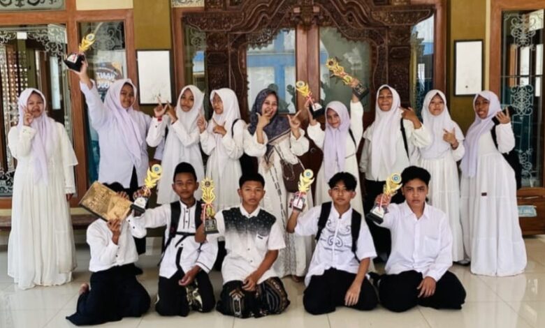 Murid SMP Muhammadiyah Keling memegang piala kejuaraan saat peringatan Hari Santri Nasional 2026
